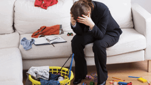 Mom overwhelmed on couch in messy living room