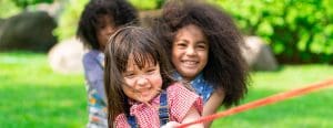 Three children pulling on a rope during tug of war