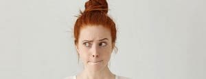Redhead mom with hair in a bun and worried look on her face