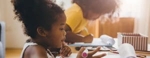Side view of two little girls working on paper work