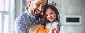 Dad holding daughter who has a little crown headband on