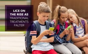 Three students outside school with backpacks on their phones
