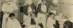 Vintage photo of nurses looking through children's hair for head lice