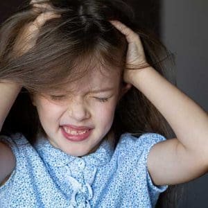 Little girl with an itchy head from head lice